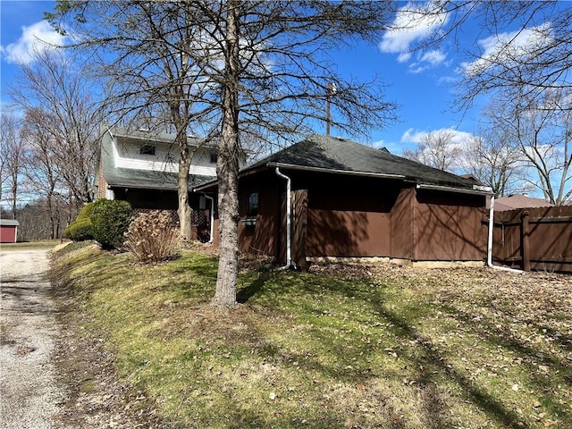 view of home's exterior with driveway and fence