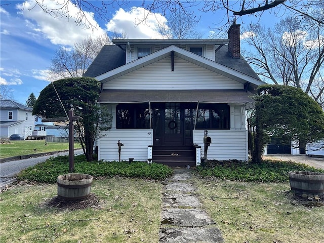 view of front of home with a sunroom and a chimney