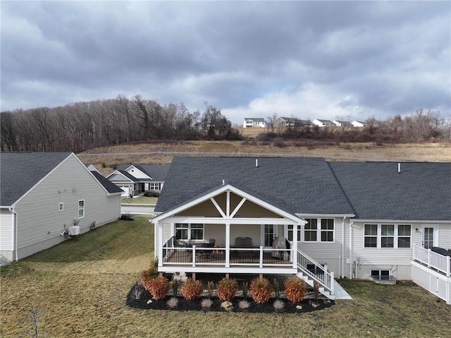 rear view of property featuring a lawn