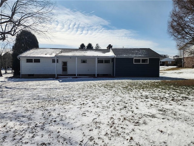 view of snow covered rear of property