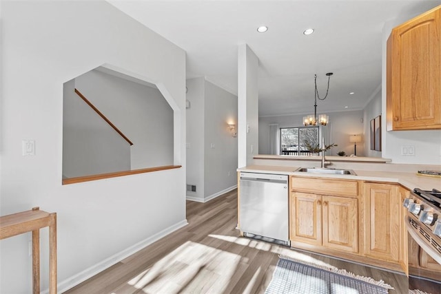 kitchen with light brown cabinetry, light wood-type flooring, stainless steel appliances, pendant lighting, and sink