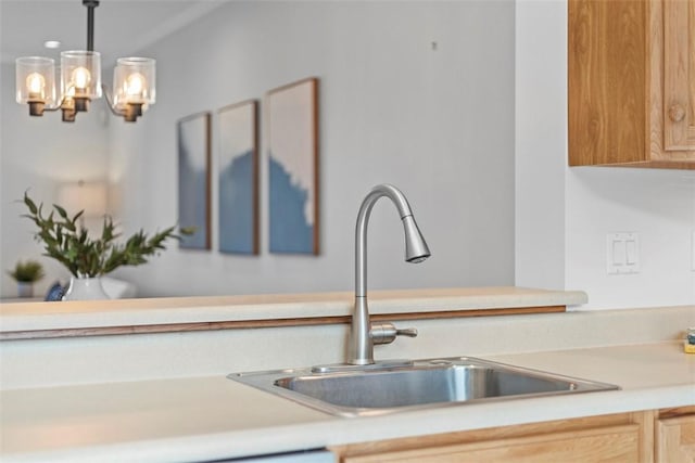 kitchen featuring sink, light brown cabinets, and pendant lighting