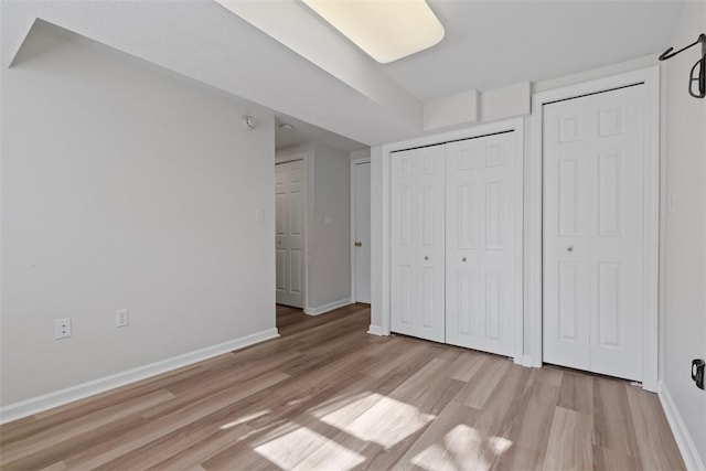 unfurnished bedroom featuring light hardwood / wood-style flooring and a closet