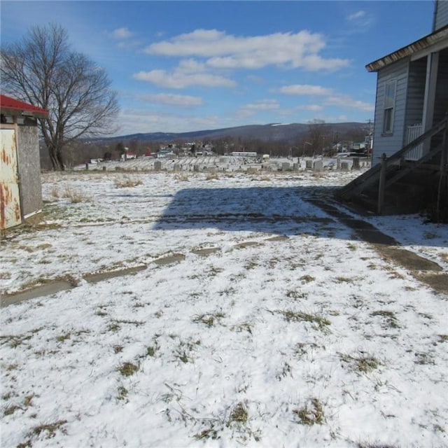 yard layered in snow featuring a mountain view