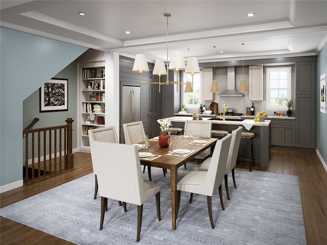 dining space with ornamental molding, dark wood-type flooring, a raised ceiling, and a healthy amount of sunlight