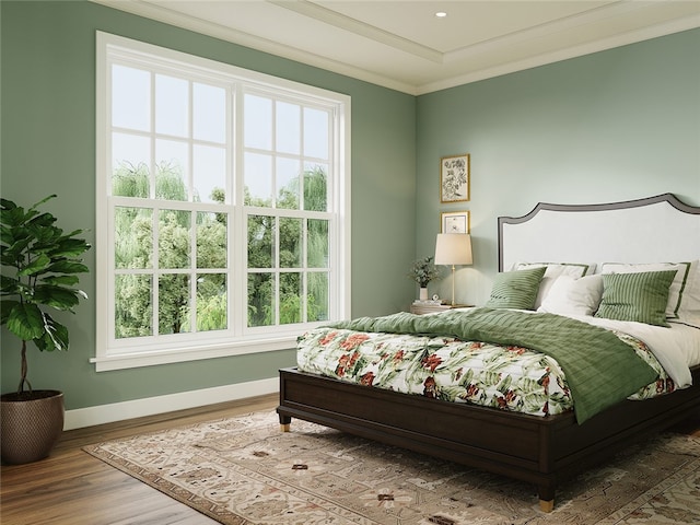 bedroom featuring multiple windows, ornamental molding, and hardwood / wood-style flooring