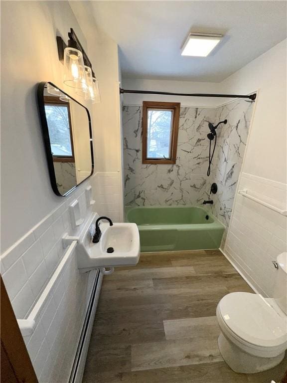 302 S Main St, Masontown, PA 15461 - bathroom with tile walls, washtub / shower combination, wood finished floors, toilet, and a wainscoted wall