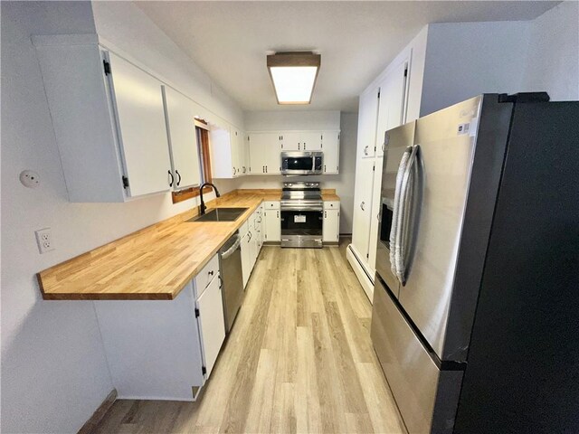 302 S Main St, Masontown, PA 15461 - kitchen with stainless steel appliances, a sink, light wood-type flooring, and a baseboard radiator