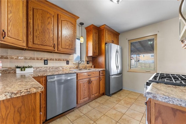 kitchen featuring stainless steel appliances, decorative light fixtures, backsplash, light tile patterned floors, and sink