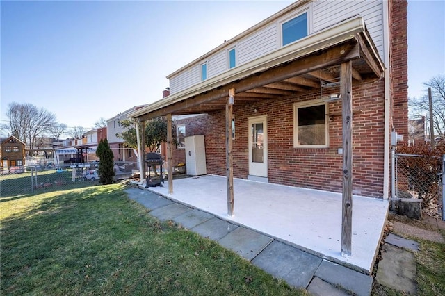 back of house with a patio area and a lawn