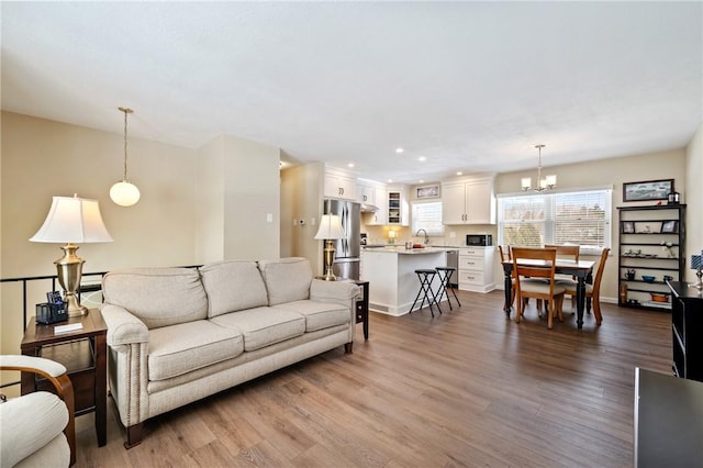 living room featuring sink, hardwood / wood-style flooring, and a chandelier