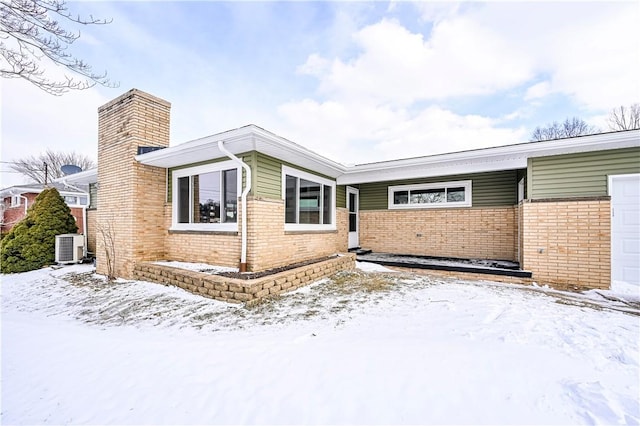 view of front of home with central AC unit and a garage