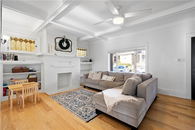 living room with wood-type flooring, ceiling fan, coffered ceiling, a fireplace, and beamed ceiling