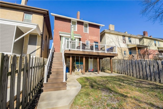 back of property featuring a lawn and a deck