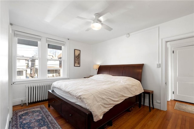 bedroom featuring ceiling fan, radiator, and dark hardwood / wood-style floors