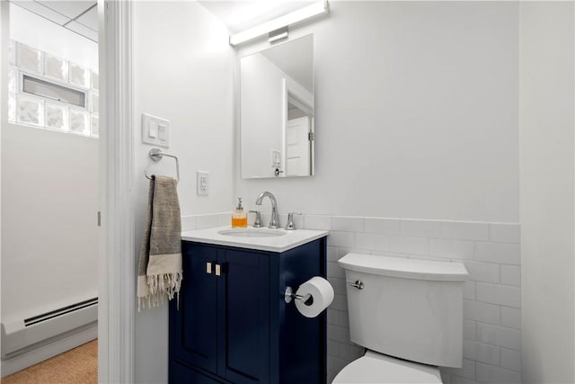 bathroom with vanity, a baseboard heating unit, tile walls, and toilet