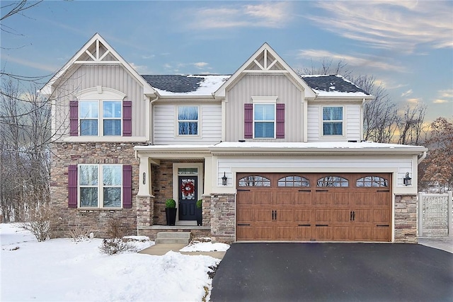 craftsman house with driveway, stone siding, a garage, and board and batten siding