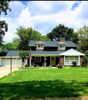 view of front facade with a front lawn and concrete driveway