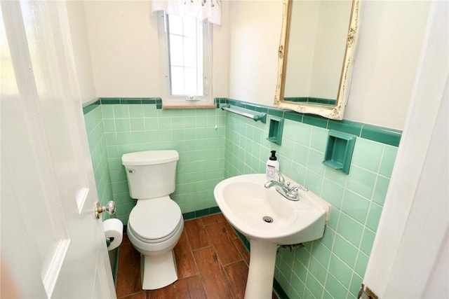 1219 Minnesota Ave, Natrona Hts/Harrison Twp, PA 15065 - bathroom featuring a wainscoted wall, a sink, toilet, tile walls, and wood finished floors