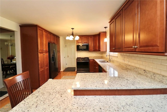 1219 Minnesota Ave, Natrona Hts/Harrison Twp, PA 15065 - kitchen featuring black refrigerator with ice dispenser, a sink, gas range oven, a notable chandelier, and light stone countertops