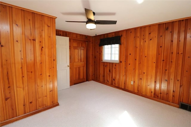 1219 Minnesota Ave, Natrona Hts/Harrison Twp, PA 15065 - carpeted empty room with visible vents, wood walls, and ceiling fan