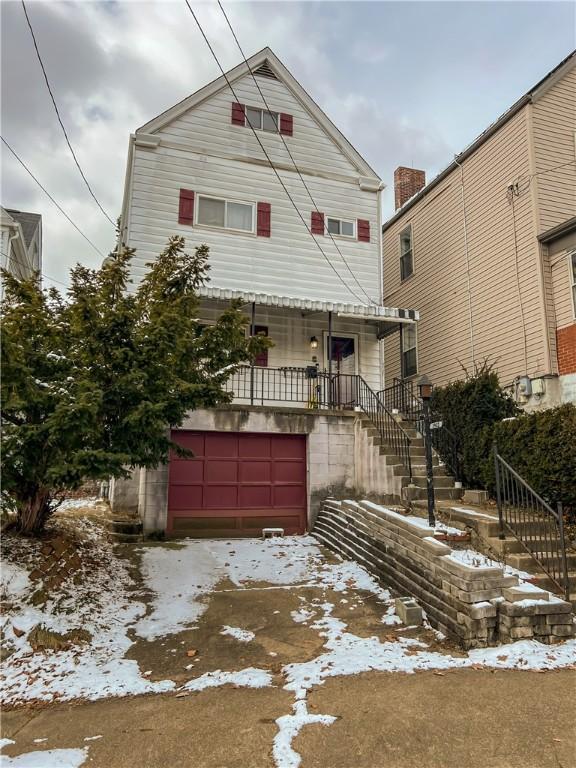 view of front of property with a garage and stairway