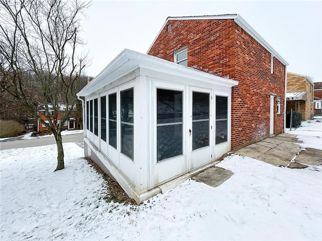 view of snow covered exterior featuring a sunroom