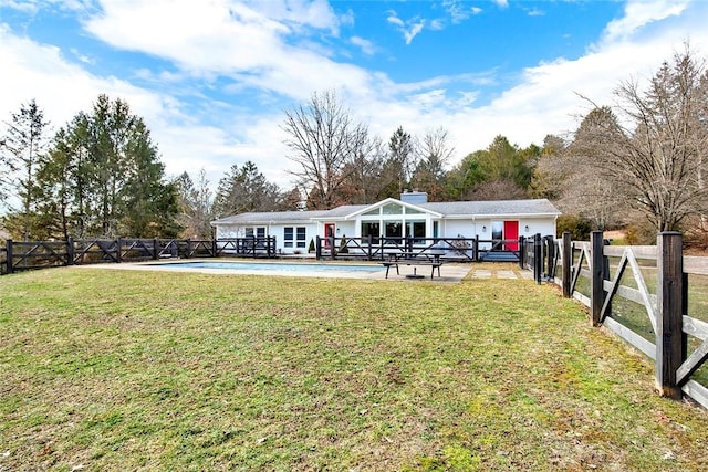 back of house with a lawn, a fenced in pool, and a patio area