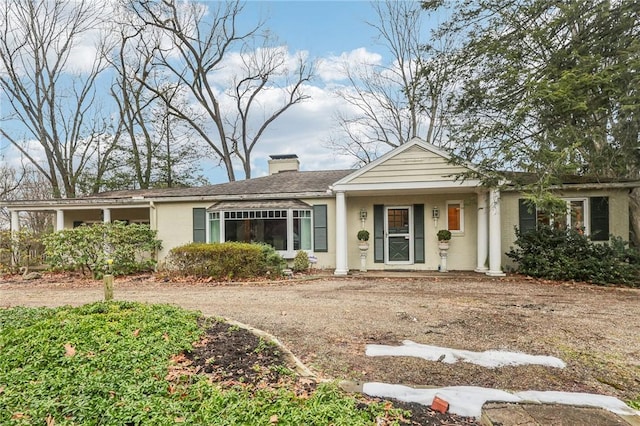 single story home featuring a chimney and stucco siding