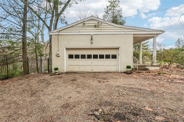 garage featuring driveway and fence