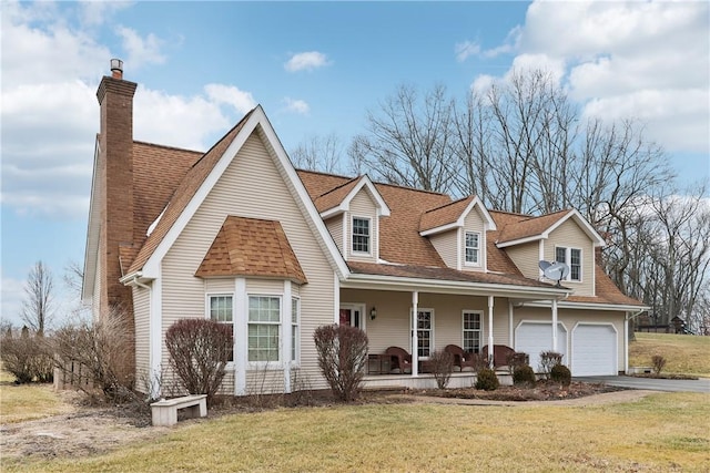 cape cod-style house featuring covered porch, a front lawn, and a garage