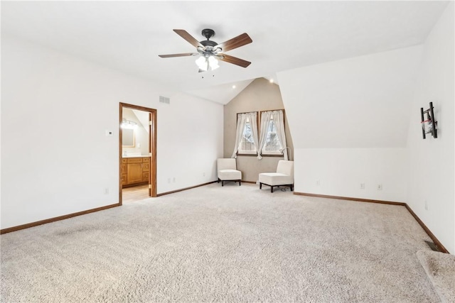 interior space with vaulted ceiling, light colored carpet, and ceiling fan