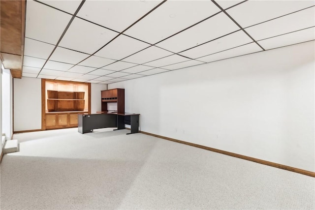 interior space with carpet, a paneled ceiling, and built in features