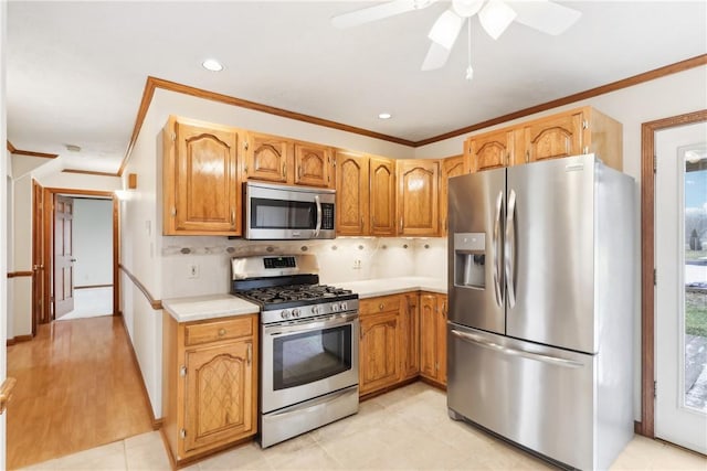 kitchen featuring crown molding, stainless steel appliances, backsplash, and ceiling fan