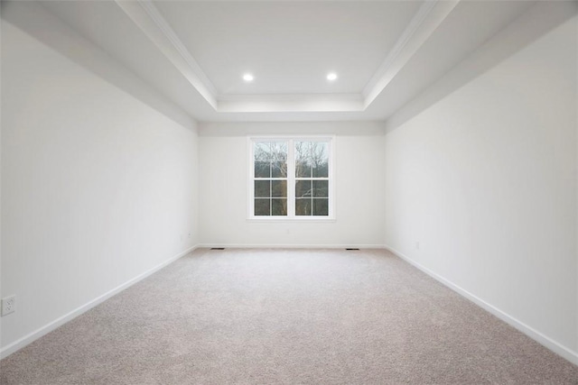 carpeted spare room with baseboards, a tray ceiling, crown molding, and recessed lighting