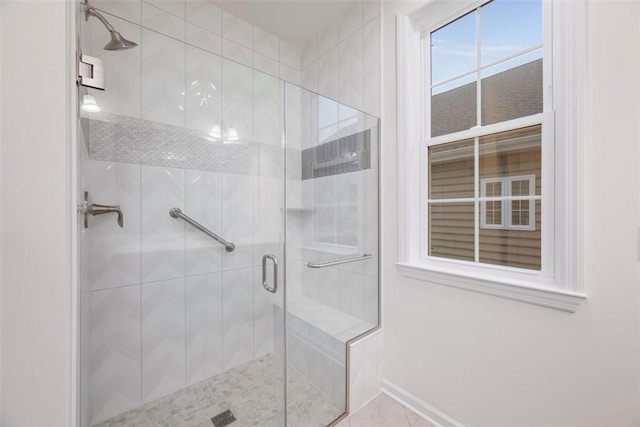 bathroom featuring a stall shower and baseboards