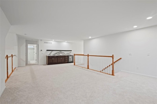 spare room with recessed lighting, visible vents, light carpet, and baseboards