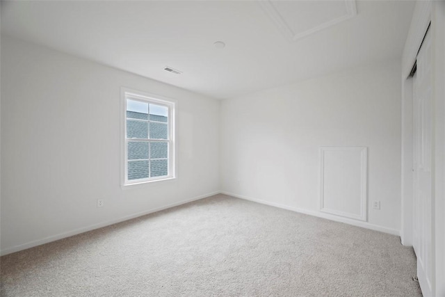 carpeted empty room featuring visible vents and baseboards