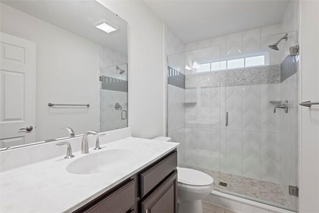 bathroom featuring toilet, a stall shower, and vanity