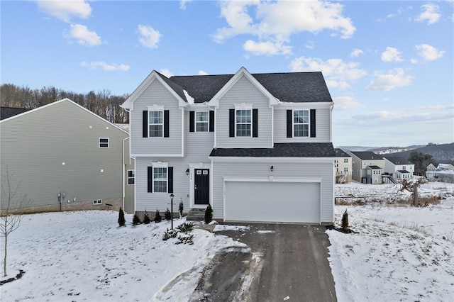 view of front of property featuring an attached garage and a shingled roof