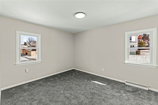 carpeted empty room featuring plenty of natural light and baseboard heating