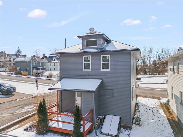 view of snow covered rear of property