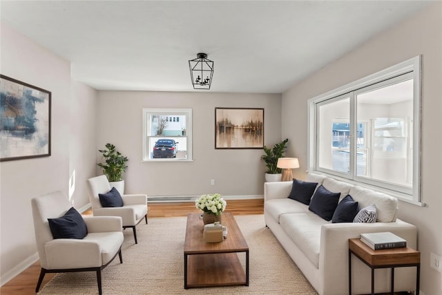 living room with light wood-type flooring, plenty of natural light, and a baseboard radiator