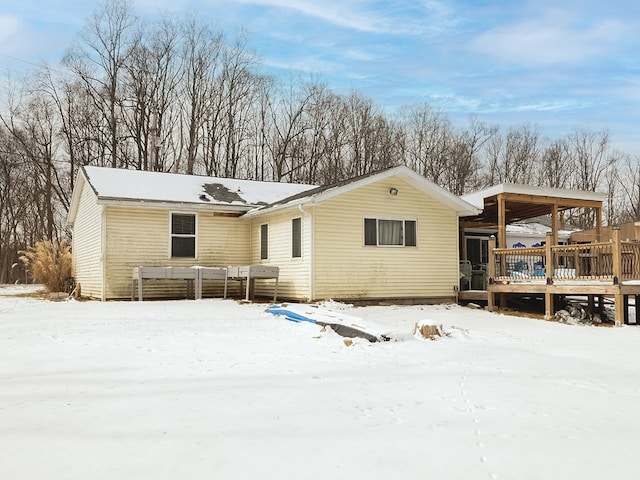 snow covered property with a wooden deck