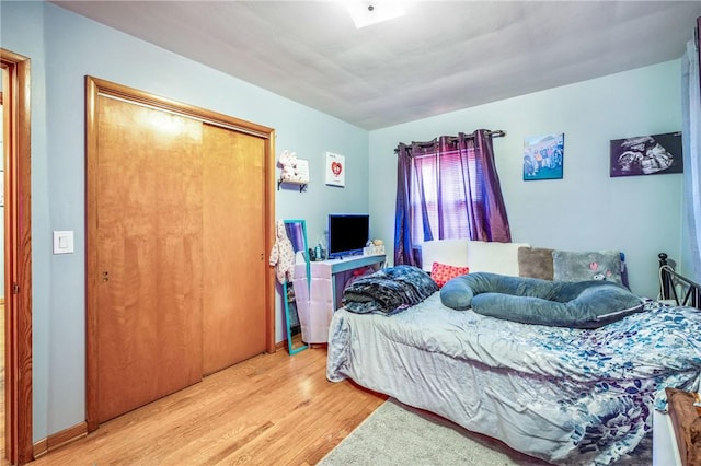 bedroom with light hardwood / wood-style flooring and a closet