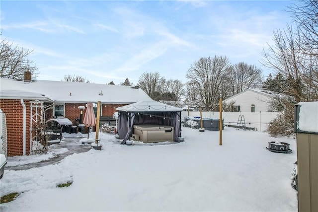 yard covered in snow featuring a hot tub