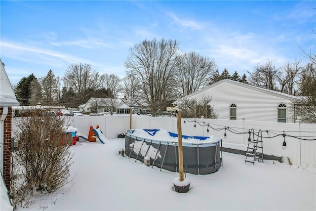 yard layered in snow with a covered pool