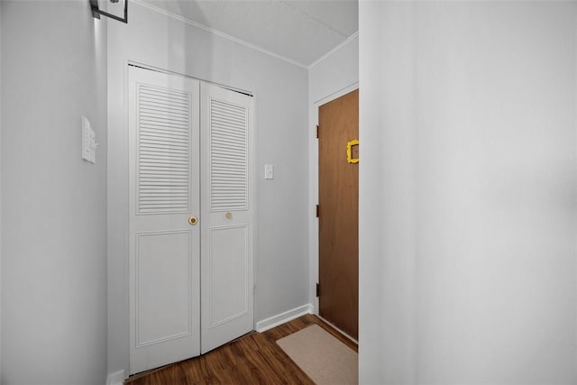 hallway with ornamental molding and dark wood-type flooring