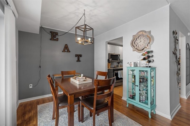 dining space with hardwood / wood-style flooring and a chandelier