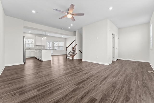 unfurnished living room with dark wood-type flooring and ceiling fan